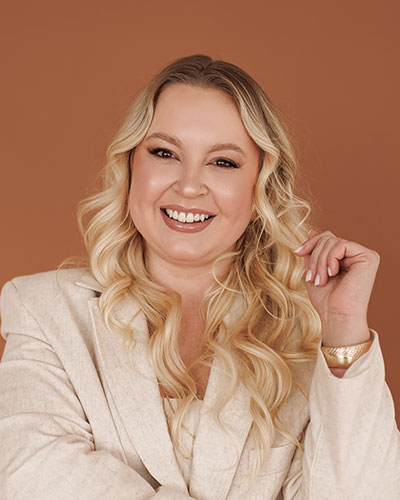 Doutora Monique First de blazer bege e fundo marrom